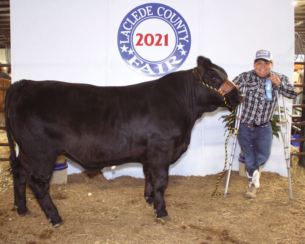 After breaking his leg. John “L.J.” Isbell has been unable to use his prosthetic leg, but it did not stop him from showing a steer this summer. Photo by Julie Turner-Crawford.
