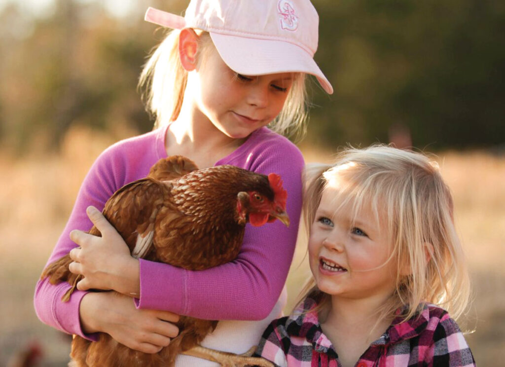 Tucker and Ellis Mae with chicken. Submitted Photo. 