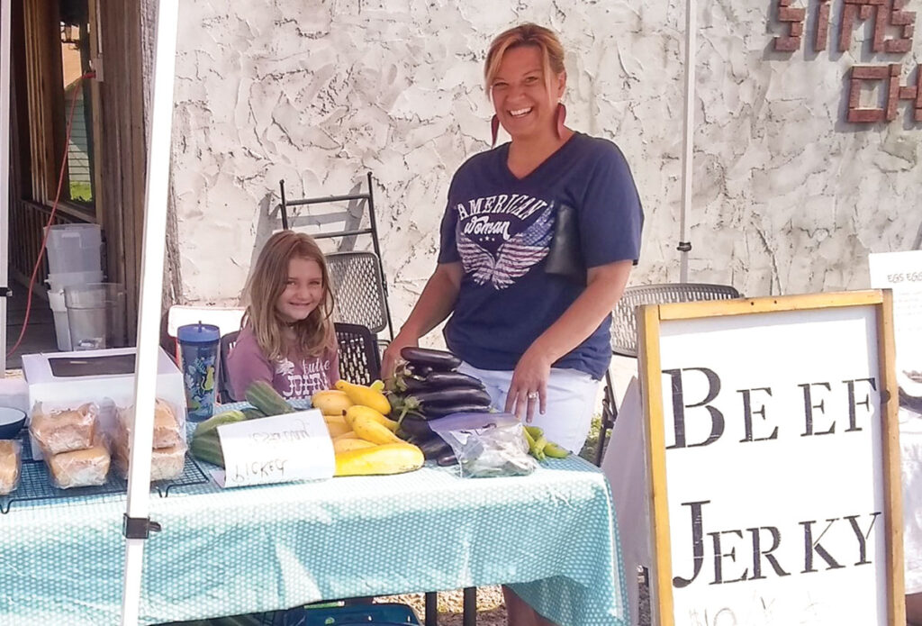 Amy Sauerwein with her daughter working their booth at the local Farmer's Market. Submitted Photo. 