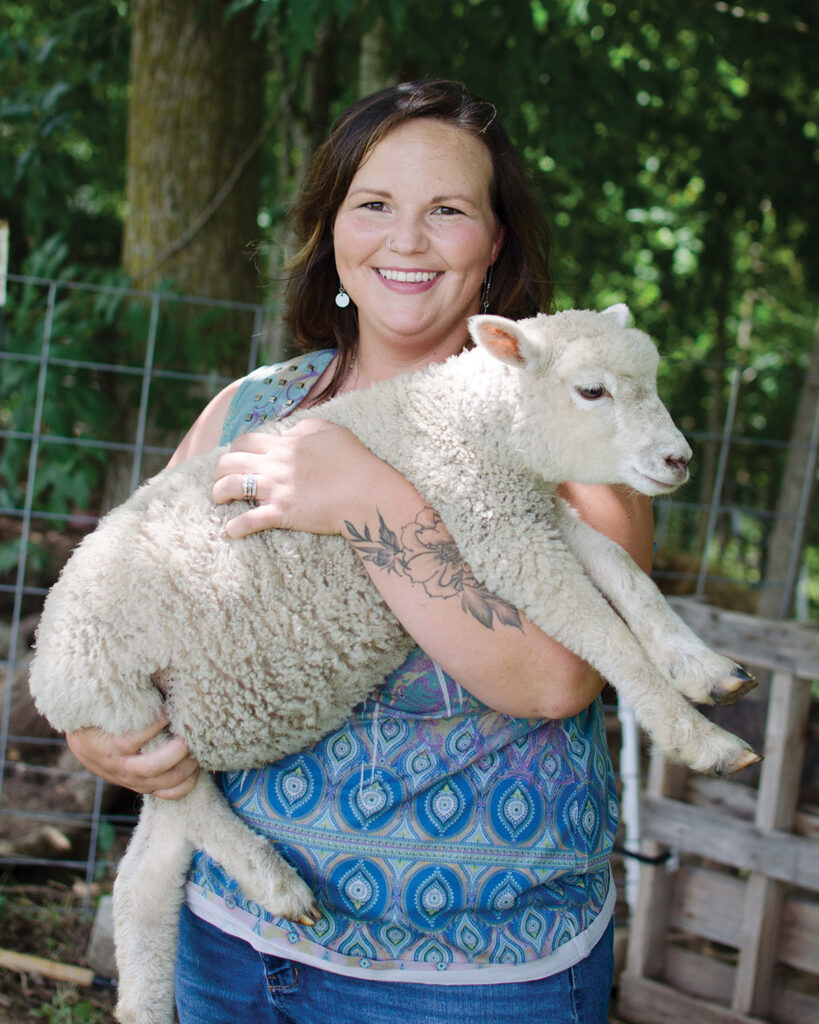 Megan Young, from Buffalo, Missouri, holding her sheep. Megan sells wool harvested from her farm in her yarn shop, The Village Yarnery. Photo by Ashley Wilson.