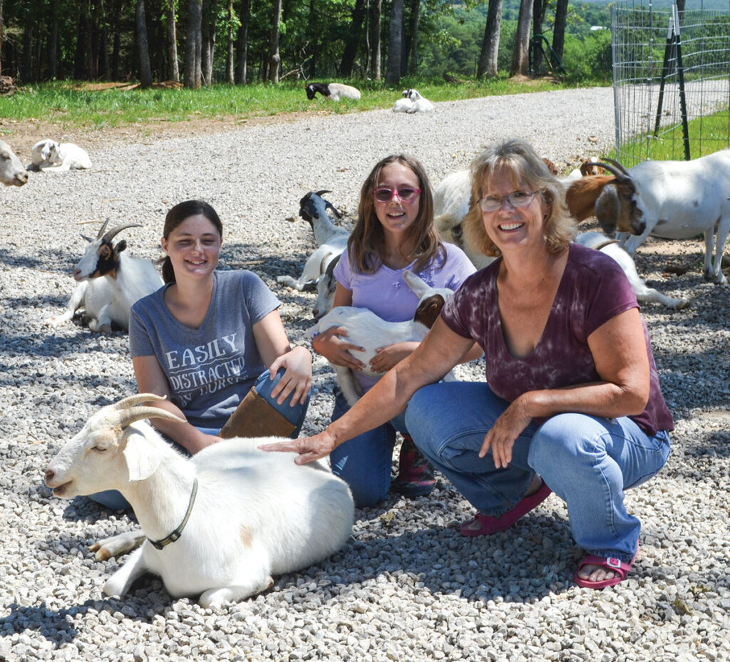 Loridian Bromberek-Reading, pictured with her granddaughters Emily Strohl (13) and Natalie Strohl (10), has a herd of mostly Boer-influenced goats, with some dairy animals as well. Photo by Laura L. Valenti.