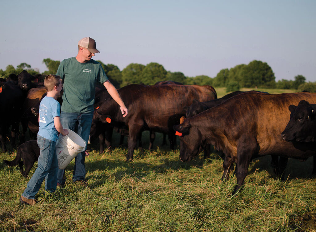 Clint Hetherington and his son Cole feeding cattle. Photo by Ashley Wilson.