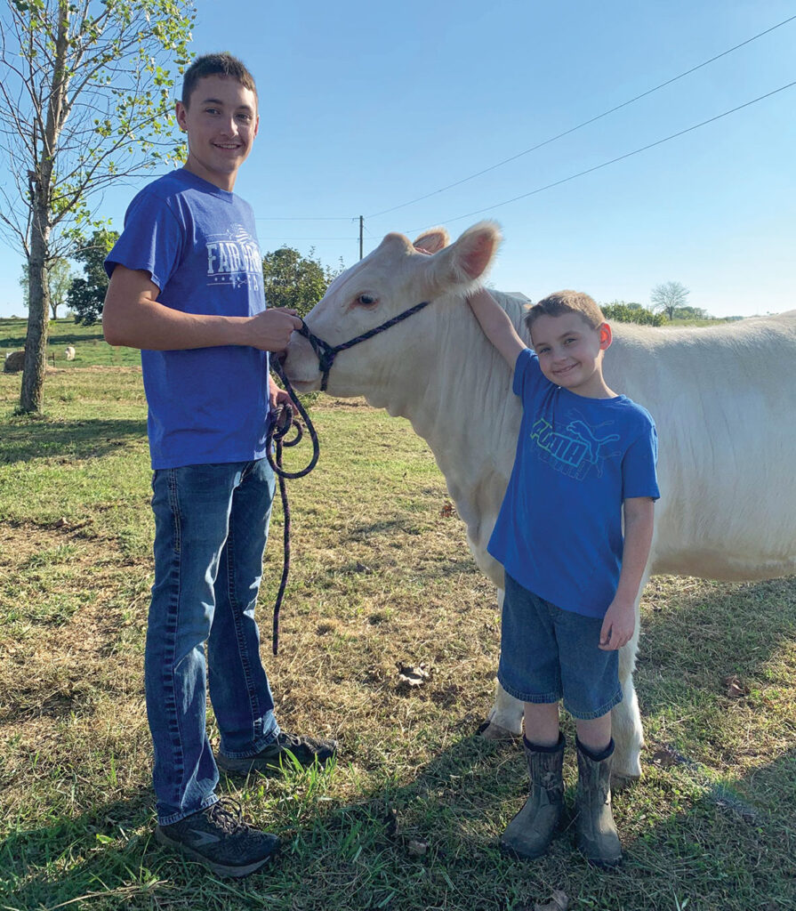 Braden Booth, pictured with his younger brother Baylen, is very involved in his family’s cattle operation, and shows registered Charolais cattle. Photo by Amanda Bradley. 