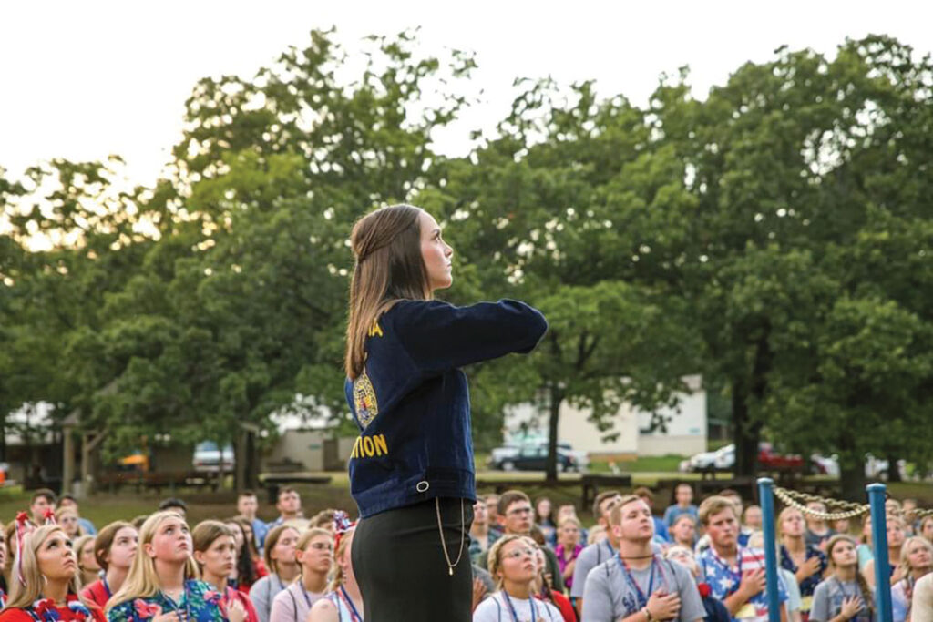 Quetta Woodall saluting the Nation’s colors during the traditional patriotic flag lowering taking place at Oklahoma FFA Alumni Leadership Camp. Submitted Photo.