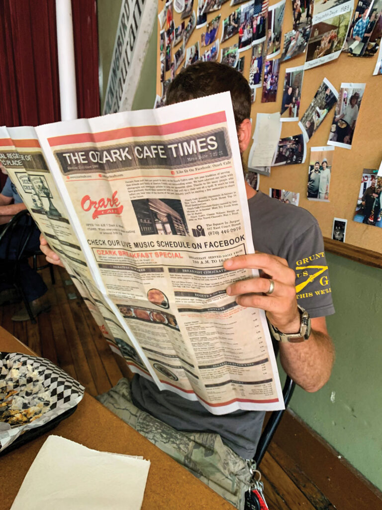 A gentlemen reading a copy of the Ozark Cafe times paper. Photo by Amanda Bradley.