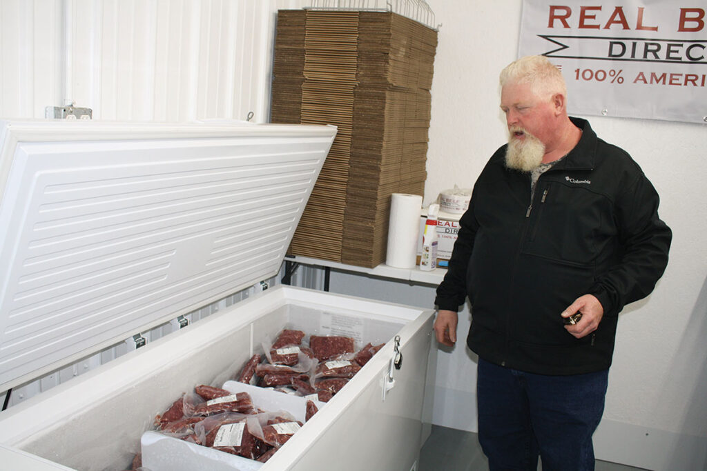 Scott Bass of Bass Livestock Nutrition showing one of the freezers for customers to access with their code.