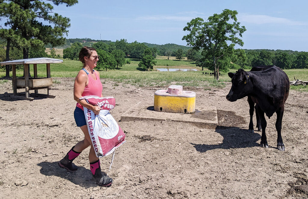 Erin Thompson carrying a bag of feed out to the cattle. Photo by Eileen J. Manella.