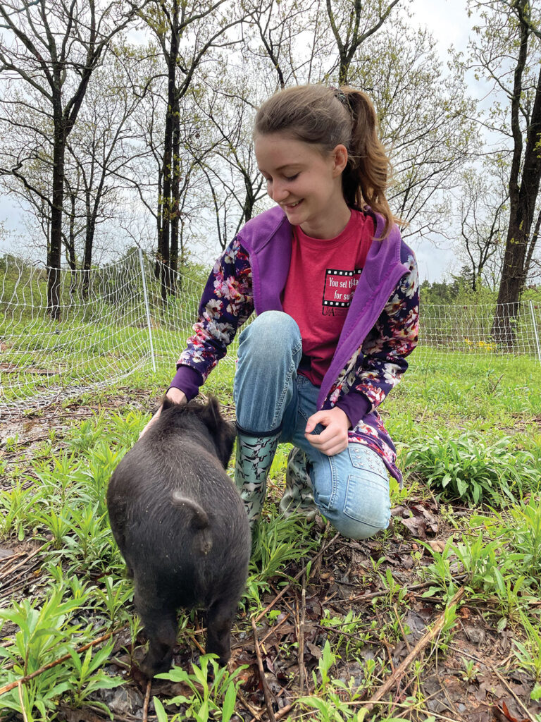 Kacey Frederick of Mansfield, Arkansas with baby piglet. Photo by Kacey Frederick.